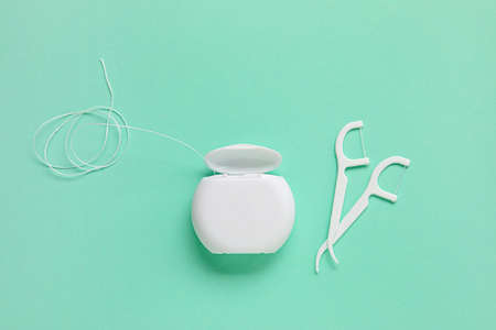 Dental floss and toothpick on green backgroundの写真素材