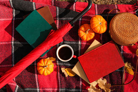 Books, cup of coffee, pumpkins, female accessories and autumn leaves on plaidの写真素材