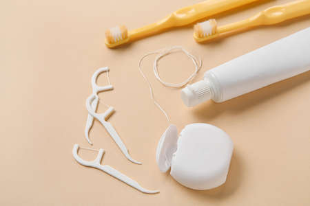 Dental floss, toothpicks, brushes and paste on beige backgroundの写真素材