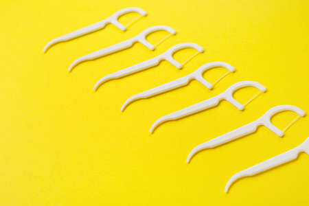 Floss toothpicks on yellow backgroundの写真素材