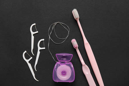 Dental floss with toothpicks and brushes on black backgroundの写真素材