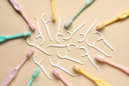 Floss toothpicks and toothbrushes on gray background