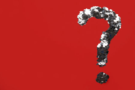 Question mark made of silver confetti on red backgroundの写真素材