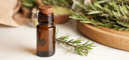 Bottle of healthy rosemary essential oil on light backgroundの写真素材