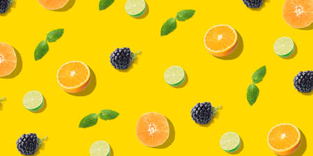Citrus fruits, berries and mint on yellow background. Pattern for designの写真素材