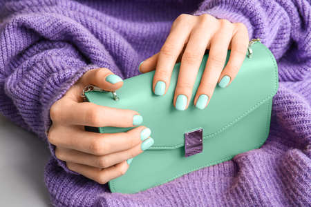 Woman with beautiful mint manicure and bag, closeupの写真素材