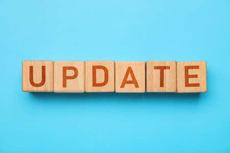 Wooden cubes with word UPDATE on light blue backgroundの写真素材