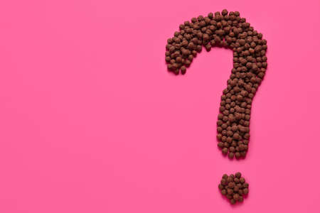 Question mark made of chocolate balls on pink backgroundの写真素材