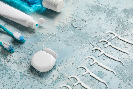 Dental floss with toothpicks, brushes, paste and rinse on grunge backgroundの写真素材