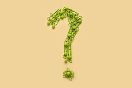 Question mark made of green paper clips on beige backgroundの写真素材