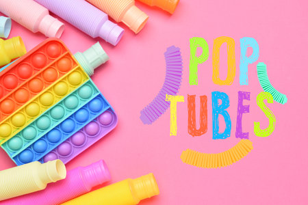 Different colorful Pop Tubes and Pop up toy on pink backgroundの写真素材