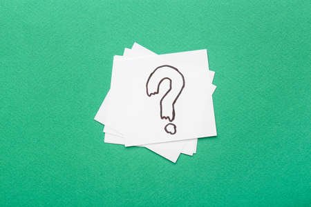 White sticky notes with question mark on green backgroundの写真素材