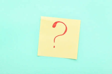 Sticky note with red question mark on blue backgroundの写真素材
