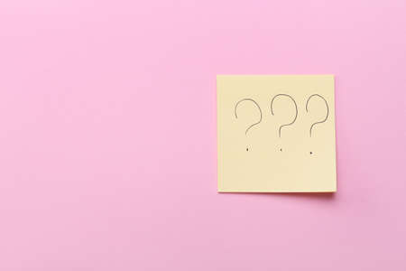 Sticky note with question mark on pink backgroundの写真素材