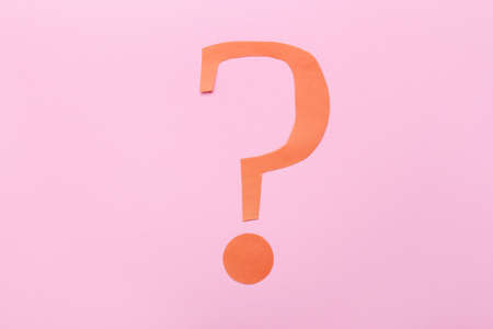 Question mark made of red paper on pink backgroundの写真素材