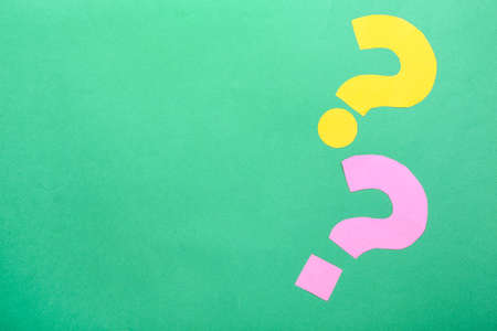 Question marks made of paper on green backgroundの写真素材