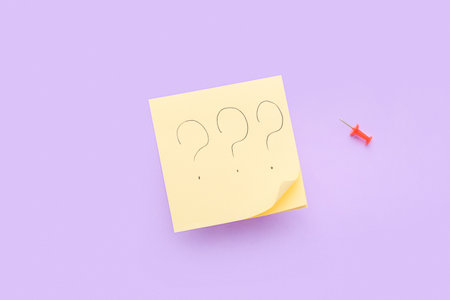 Sticky notes with question marks and pin on lilac backgroundの写真素材