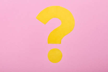 Question mark made of yellow paper on pink backgroundの写真素材