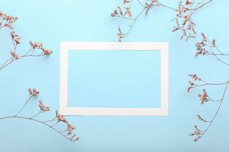 Composition with empty frame and dried flowers on blue backgroundの写真素材