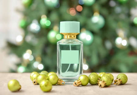Perfume bottle and Christmas balls on table against blurred backgroundの写真素材