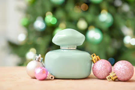 Perfume bottle and Christmas balls on table against blurred backgroundの写真素材