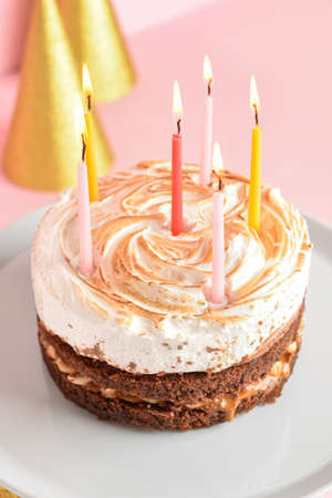 Stand with tasty birthday cake and burning candles on pink background, closeup