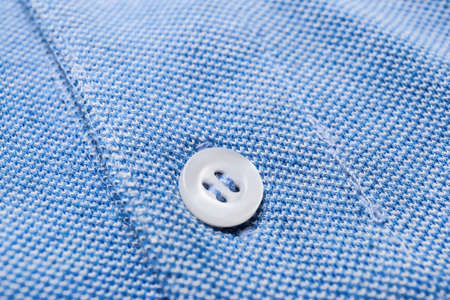 Closeup view of button on stylish blue shirtの写真素材