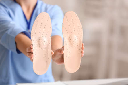 Female nurse holding orthopedic insoles in clinic, closeupの写真素材