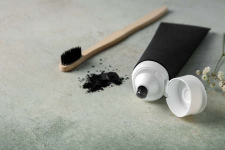 Black toothpaste with activated carbon and brush on tableの写真素材