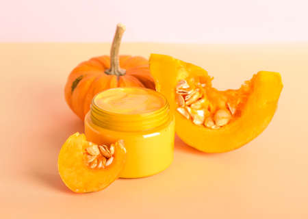 Jar of mask and ripe pumpkin on color backgroundの写真素材