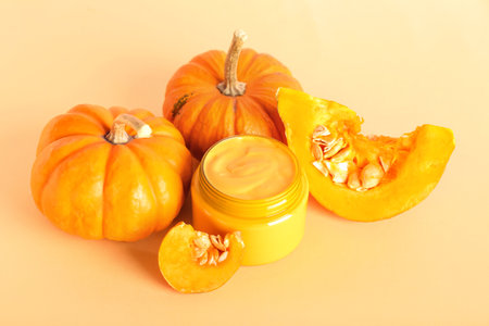 Jar of mask and ripe pumpkins on color backgroundの写真素材