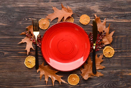 Composition with table setting and autumn leaves on wooden backgroundの写真素材