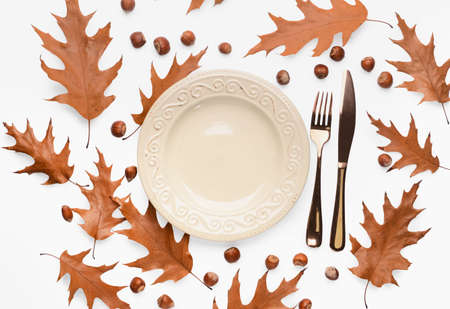 Composition with table setting and autumn leaves on light backgroundの写真素材