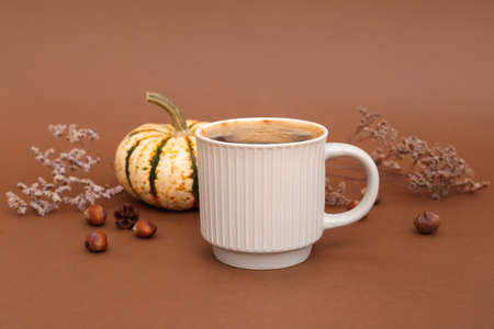 Cup of tasty pumpkin coffee on brown backgroundの写真素材