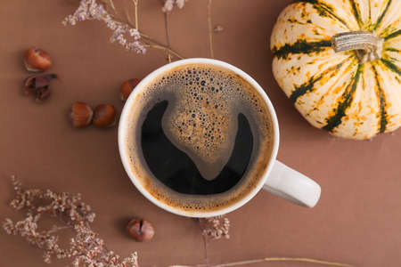 Cup of tasty pumpkin coffee on brown backgroundの写真素材