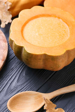 Tasty soup served in pumpkin on black wooden backgroundの写真素材
