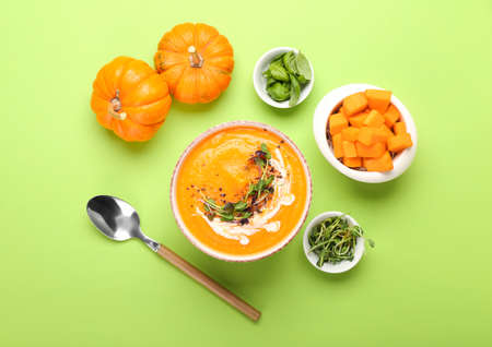 Bowl with tasty pumpkin cream soup on green backgroundの写真素材