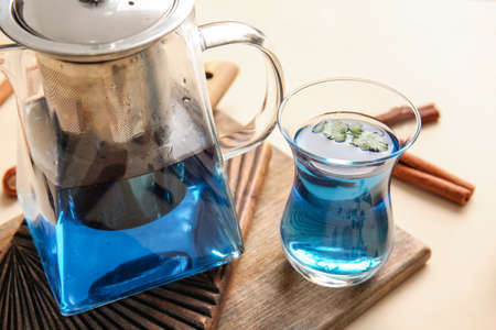 Teapot and cup of blue tea on color background, closeupの写真素材