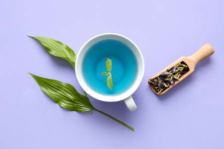 Cup of blue tea and dried butterfly pea flowers on color backgroundの写真素材