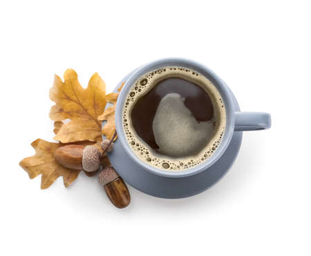Cup of coffee with acorns and autumn leaves on white backgroundの写真素材