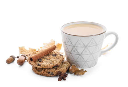 Cup of coffee with acorns, spices and tasty cookies on white backgroundの写真素材