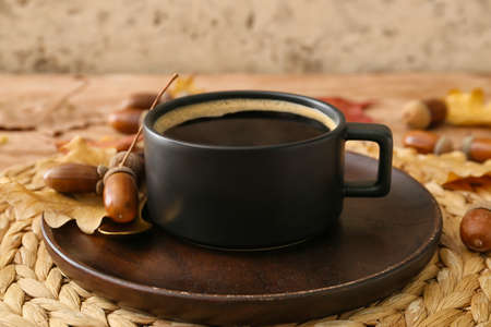 Cup of coffee with acorns and autumn leaves on table, closeupの写真素材