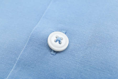 Close up view of button on blue shirtの写真素材
