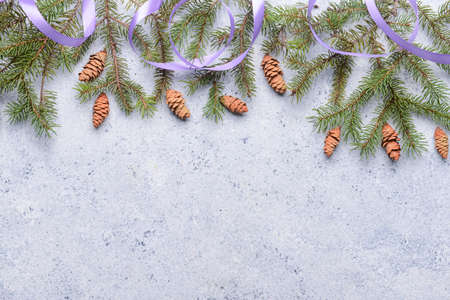 Fir branches, cones and ribbon on light backgroundの写真素材