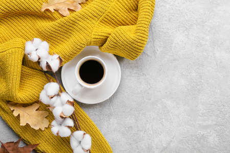 Cotton flowers, sweater and cup of coffee on light backgroundの写真素材