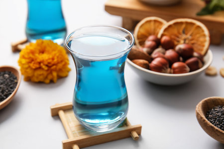 Cup of blue tea and nuts on light background, closeupの写真素材