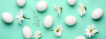 Beautiful Easter composition with eggs and spring flowers on turquoise backgroundの写真素材