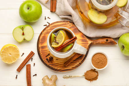 Cup of tasty fruit tea with cinnamon on white wooden backgroundの写真素材