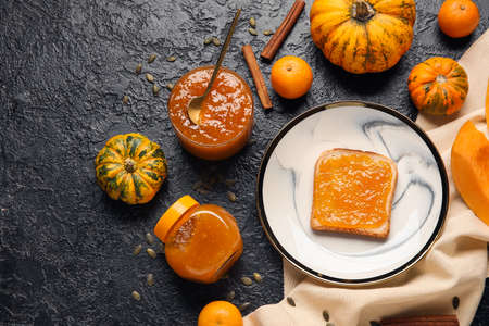 Plate of toast with sweet pumpkin jam and oranges on black backgroundの写真素材