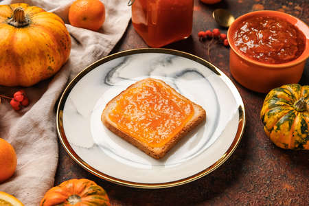 Plate with toast with sweet pumpkin jam on grunge backgroundの写真素材